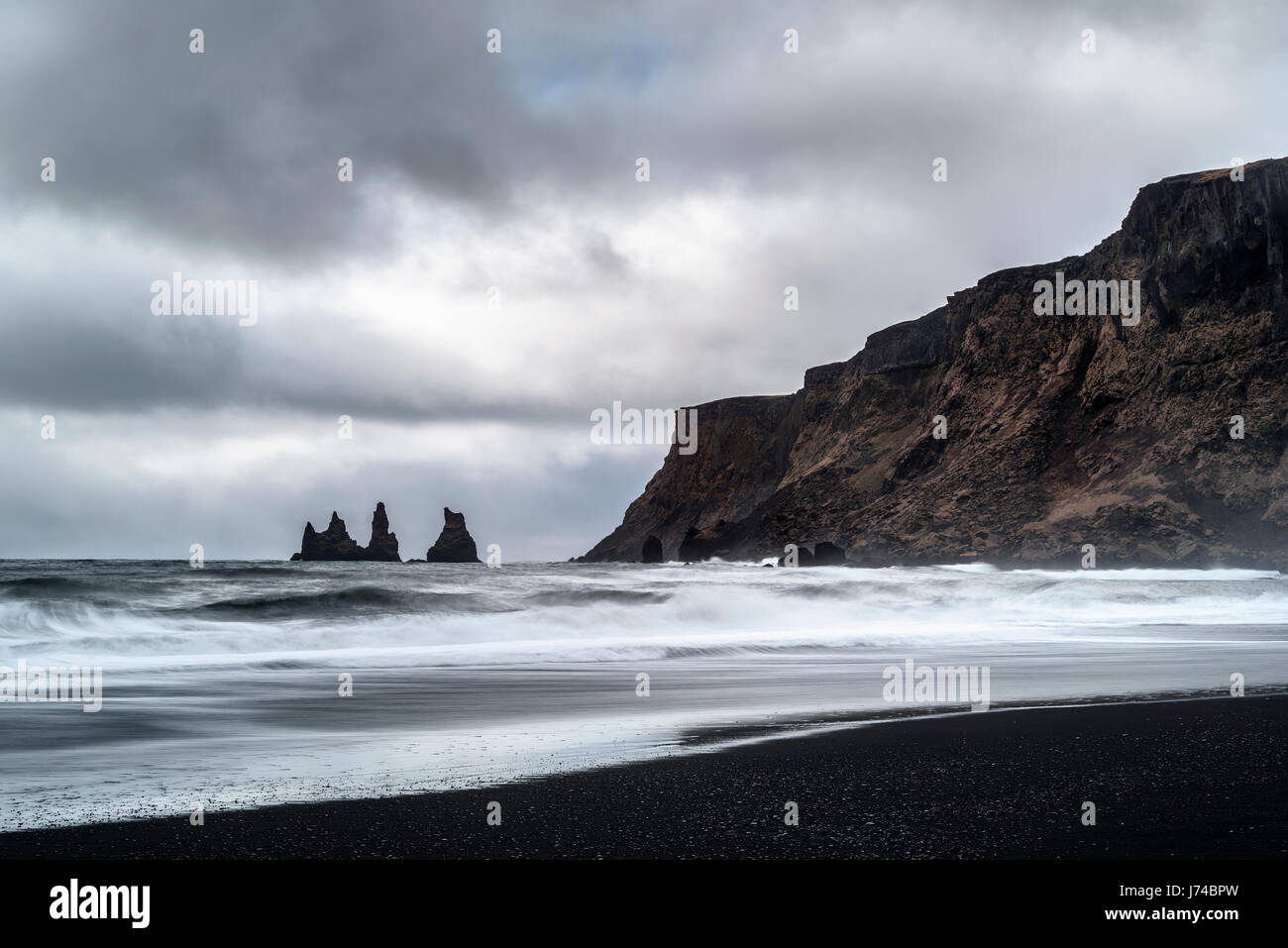 Il paesaggio della famosa spiaggia di sabbia nera in un giorno nuvoloso. Foto Stock
