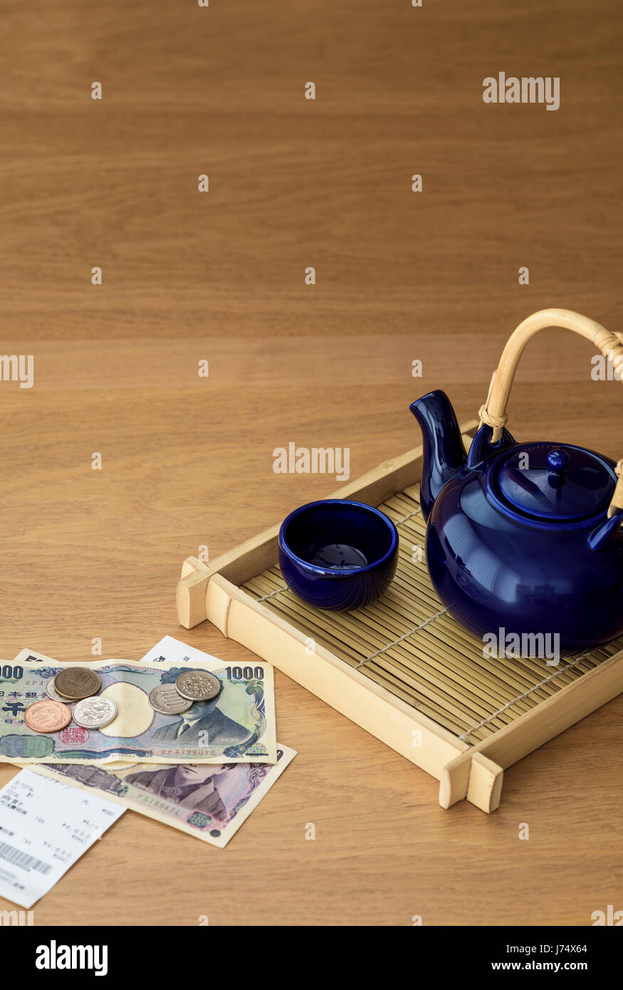 Giapponese del tè pentola sul vassoio di bambù con Yen e il ristorante di bill. Foto Stock