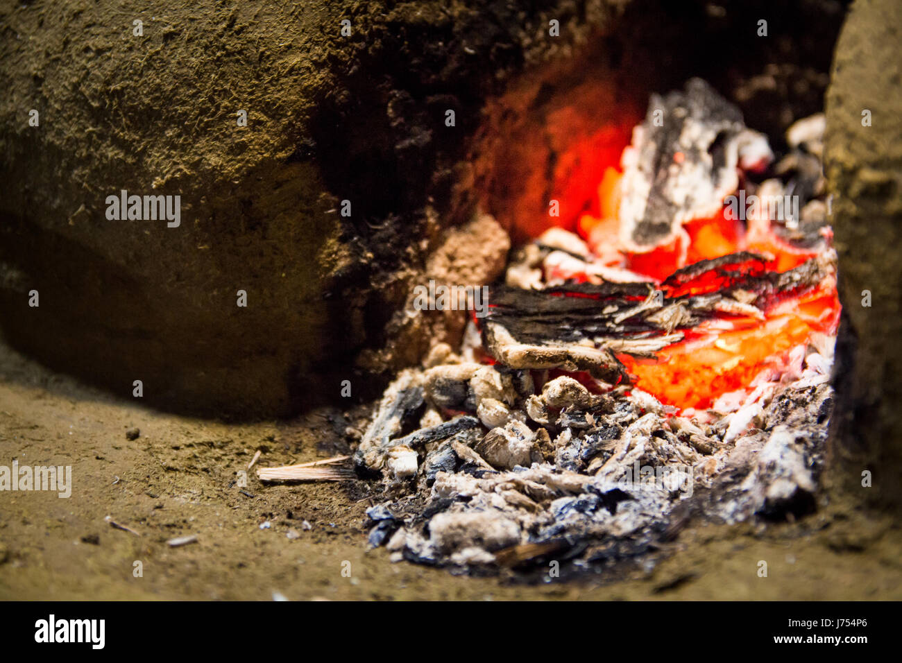 Le braci di un morente nel fuoco a legna per la stufa fatta di fango e argilla in un esterno tradizionale dello Sri Lanka la cucina. Foto Stock