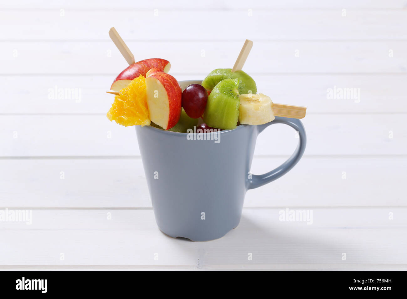 Coppa di frutta fresca spiedini di bianco su sfondo di legno Foto Stock