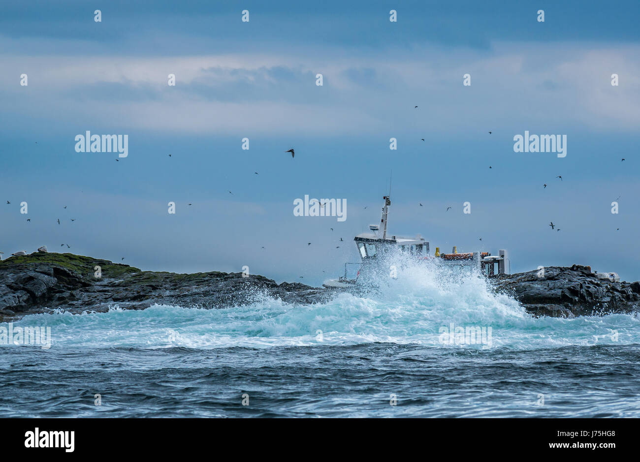 Spuma del mare con onde schizzi su rocce e piccola barca, farne Islands, Northumberland, England, Regno Unito Foto Stock