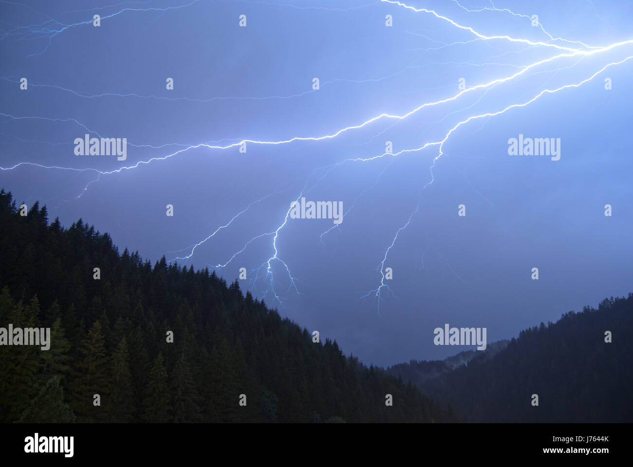 Un piano orizzontale di cloud-per-cloud fulmine in un forte temporale durante la notte su una foresta di montagna in Austria. Foto Stock