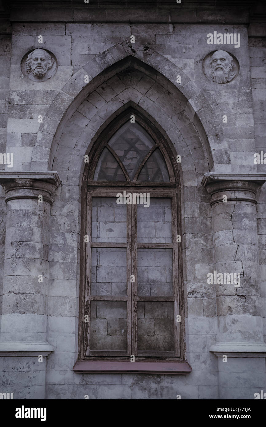Antica gotica lancet window cinta da mura con pietre Foto Stock