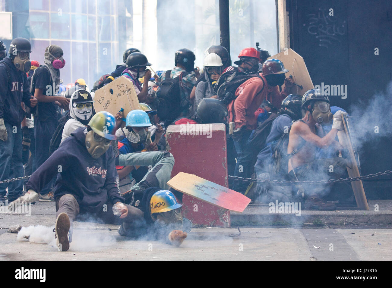 I manifestanti tenta di catturare una lacrima bombola del gas sparati dalla polizia durante una manifestazione di protesta contro il governo di nicolas maduro a Caracas. Foto Stock