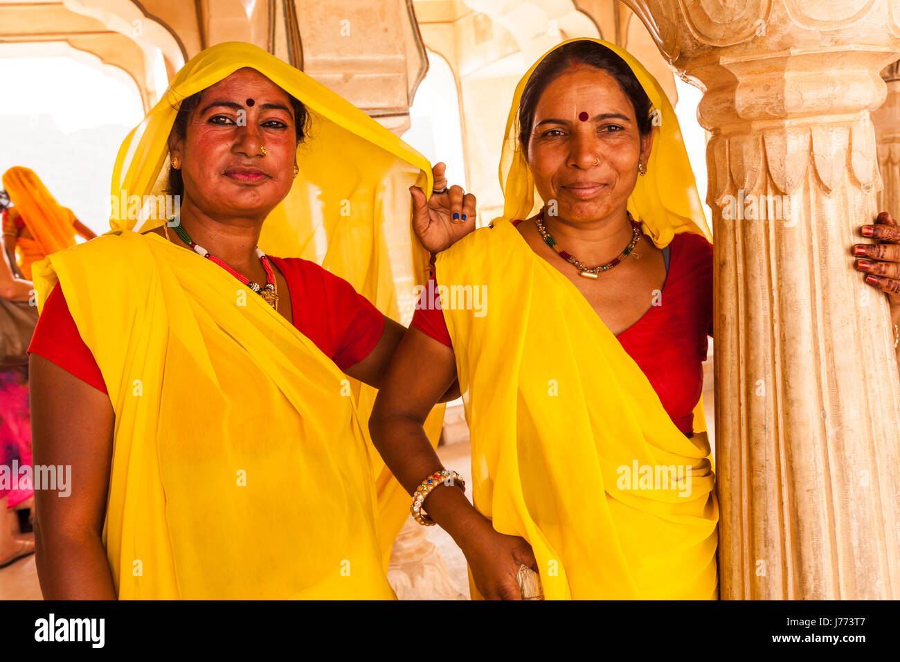 Due donne delle pulizie al Forte Amber in Jaipur India,in abiti di colore giallo a Maharaja Palace, femmina in giallo abiti fort di pulizia. Foto Stock