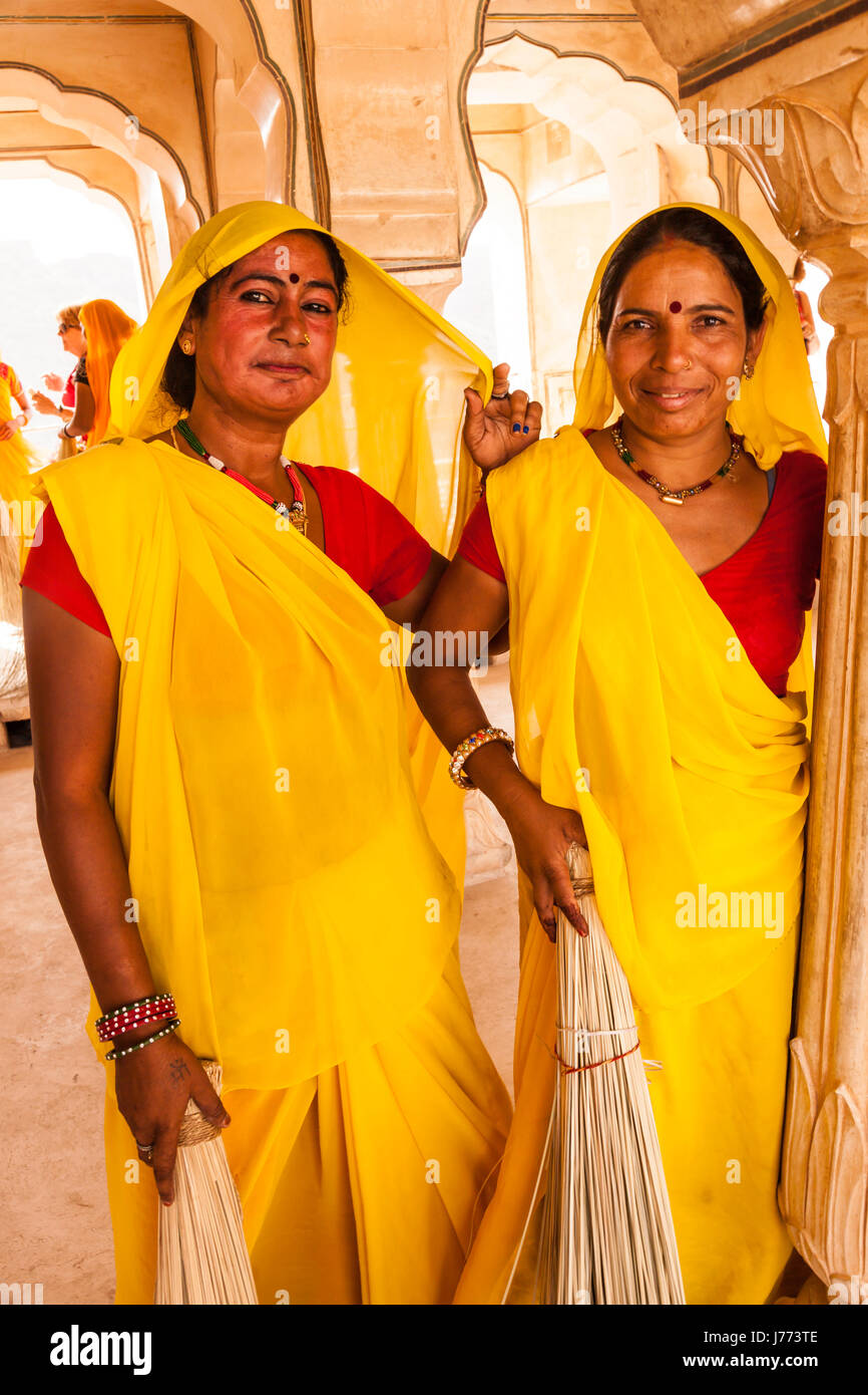 Due donne le donne delle pulizie al Forte Amber in Jaipur India,in abiti di colore giallo Foto Stock
