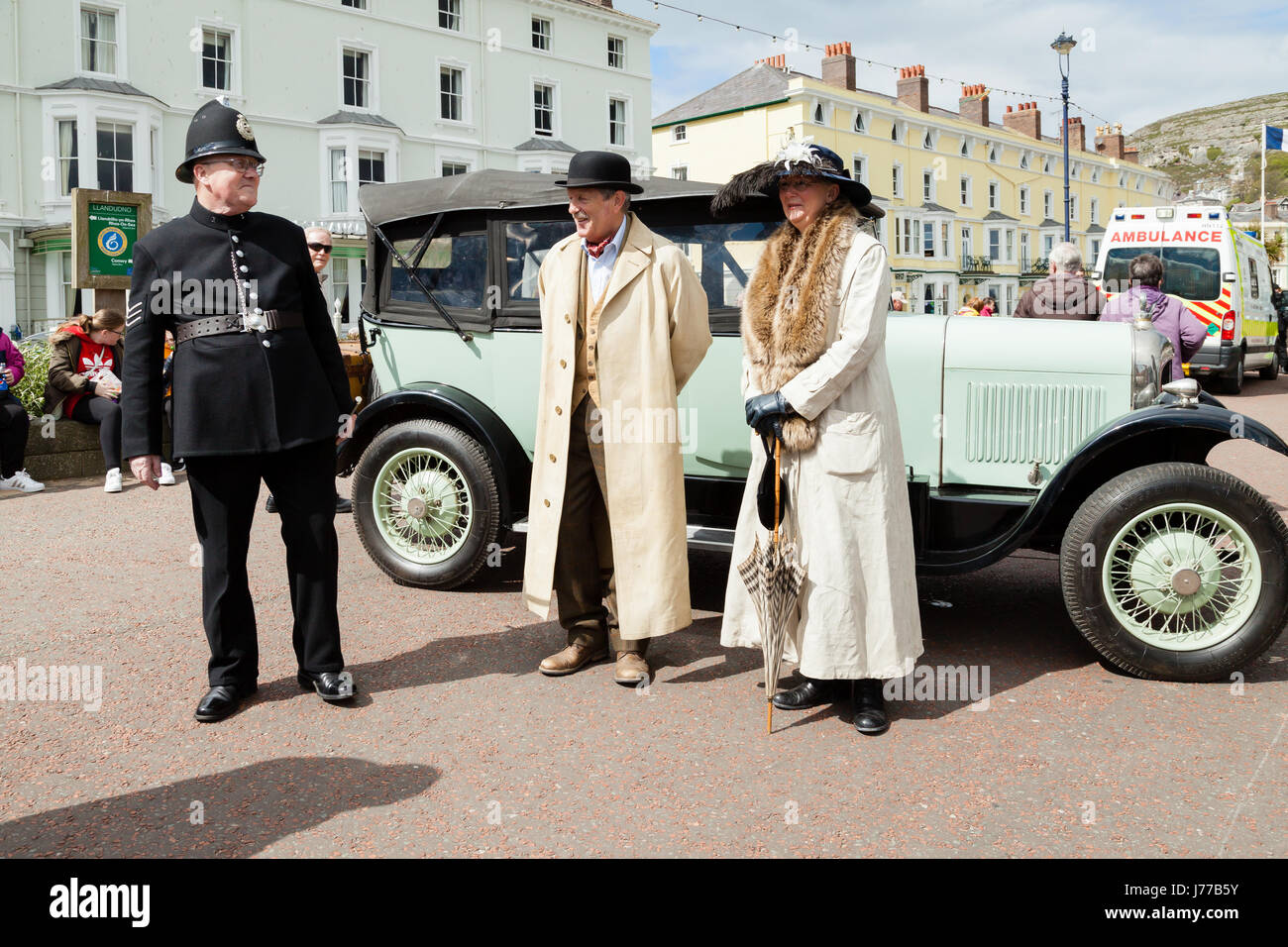 Llandudno, il Galles del Nord- 29 aprile 2017: persone vestite in costume vittoriano in piedi accanto ad un cedro vintage auto a Llandudno promenade come parte di Foto Stock