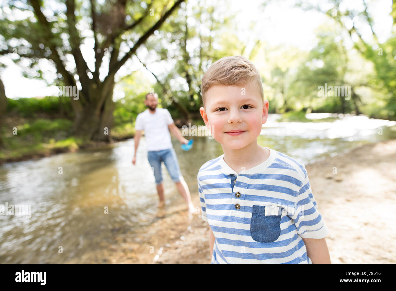 Ragazzino con il padre presso il fiume, soleggiata giornata di primavera. Foto Stock