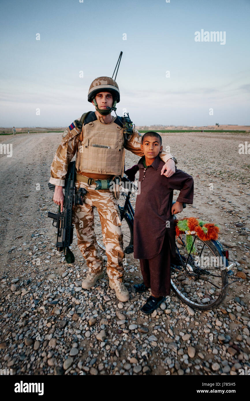 Ragazzo afghano con British solidier, Afghanistan Foto Stock