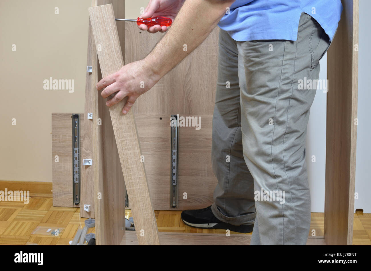 Uomo in piedi da elementi di mobili pronti per essere assemblati Foto Stock