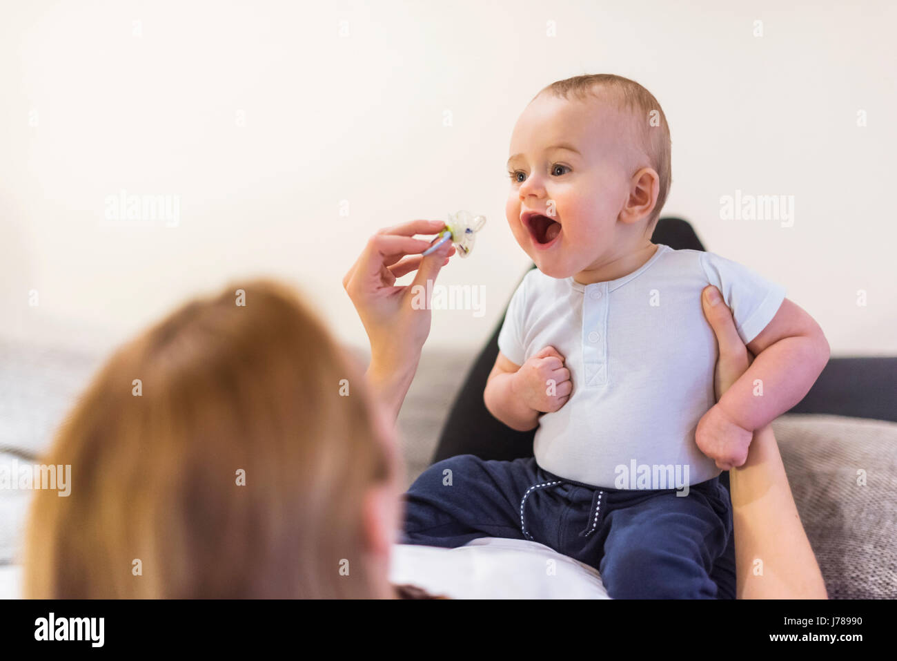 Il bambino e la madre figlio giocare con succhietto Foto Stock