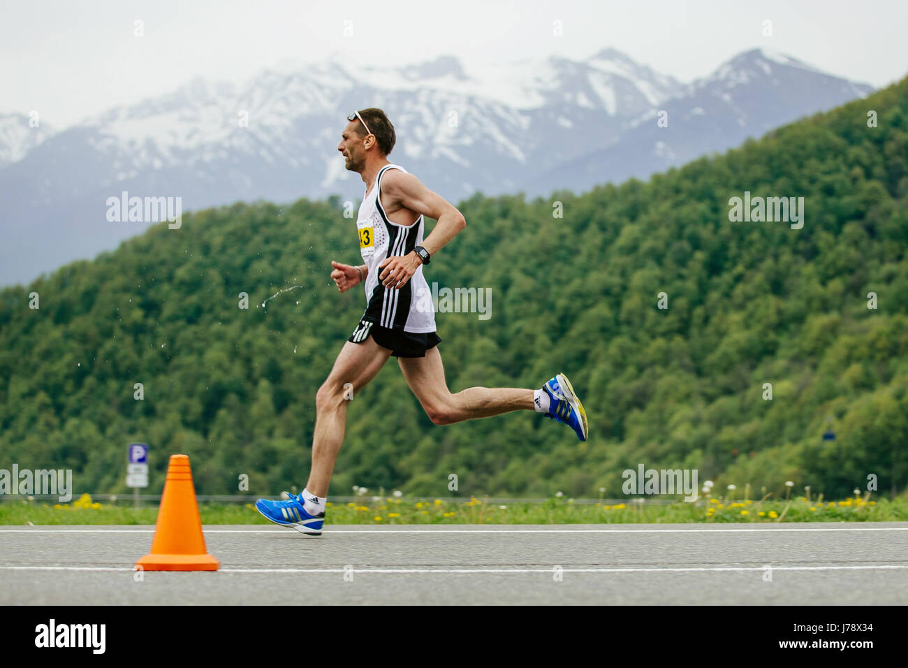 Rosa Khutor, Russia - 7 Maggio 2017: runner leader gara scorre sullo sfondo di montagne e foreste verdi in gara Spring Mountain marathon Foto Stock