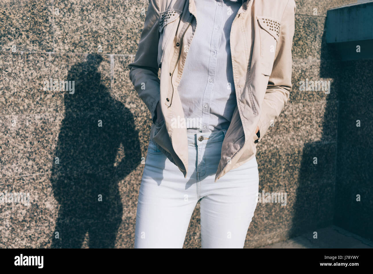 Donna in jeans e maglietta e una giacca beige in background di pareti di  marmo. Dettagli di abbigliamento femminile, close-up Foto stock - Alamy