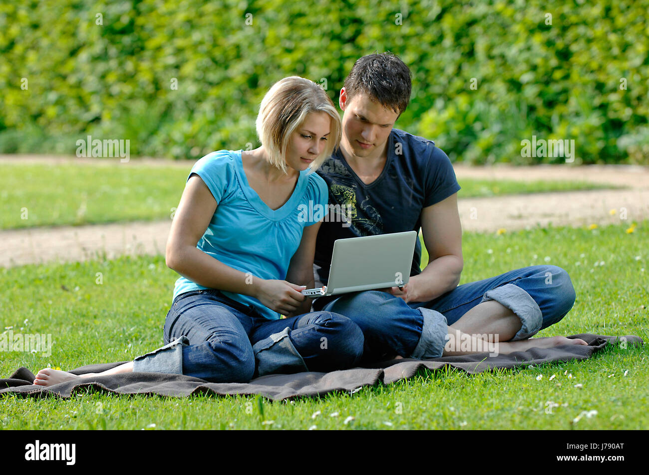 Donna laptop notebook computer computer mettere seduta sit giovane coppia comune Foto Stock