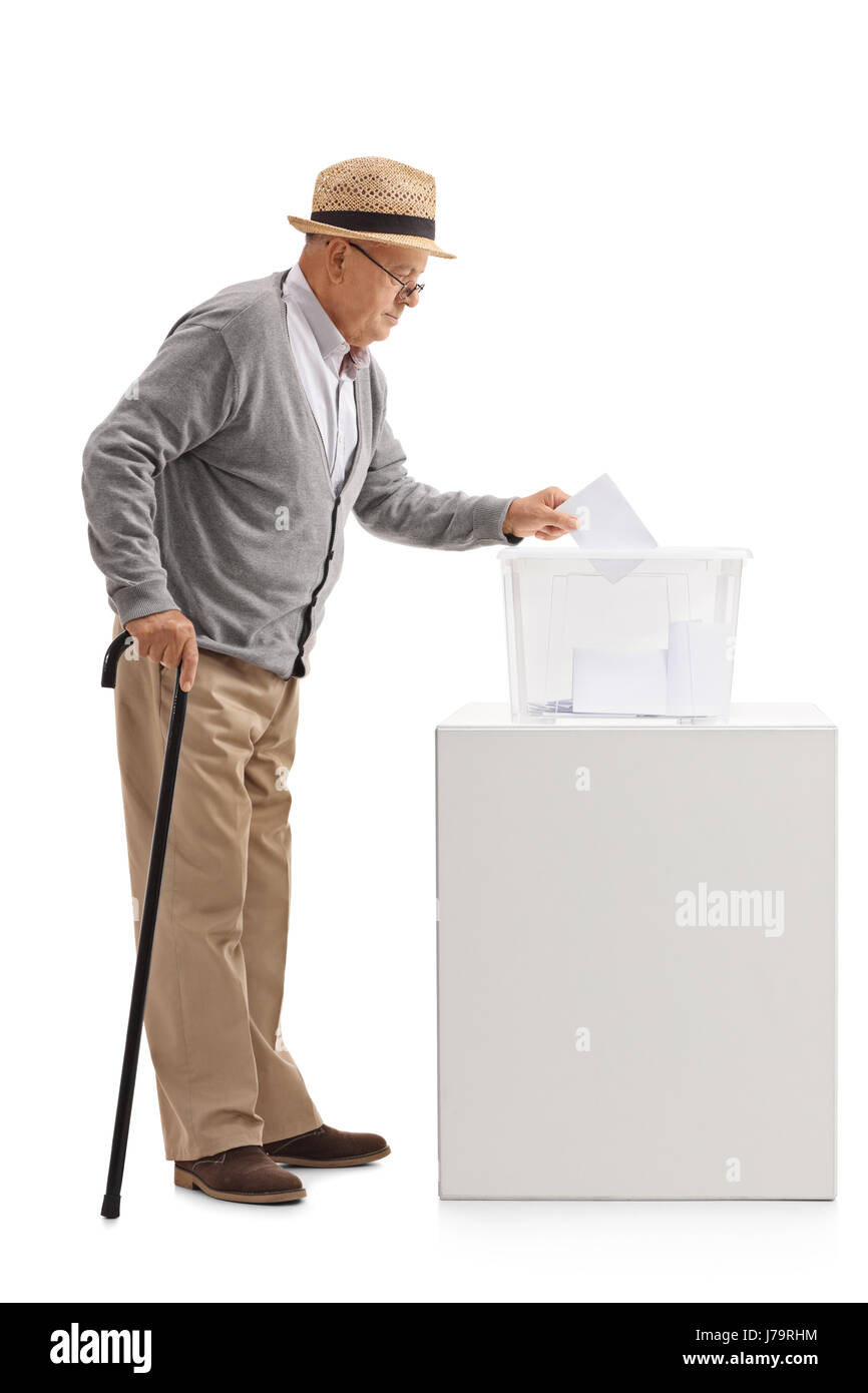 Lunghezza piena ripresa del profilo di un uomo anziano mettendo un ballottaggio in una casella di voto isolato su sfondo bianco Foto Stock