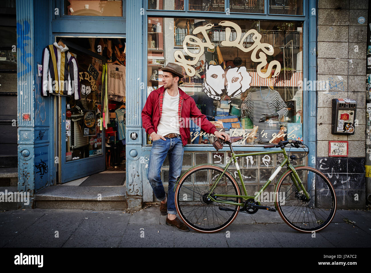 Germania, Hamburg St. Pauli, l uomo con la bicicletta in attesa nella parte anteriore del negozio vintage Foto Stock