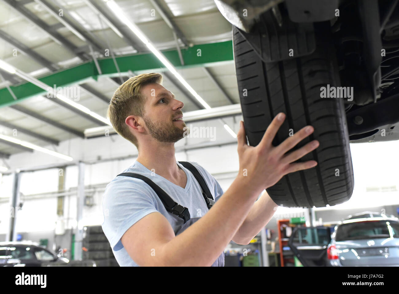 Autofficine in un workshop cambiare auto pneumatico Foto Stock