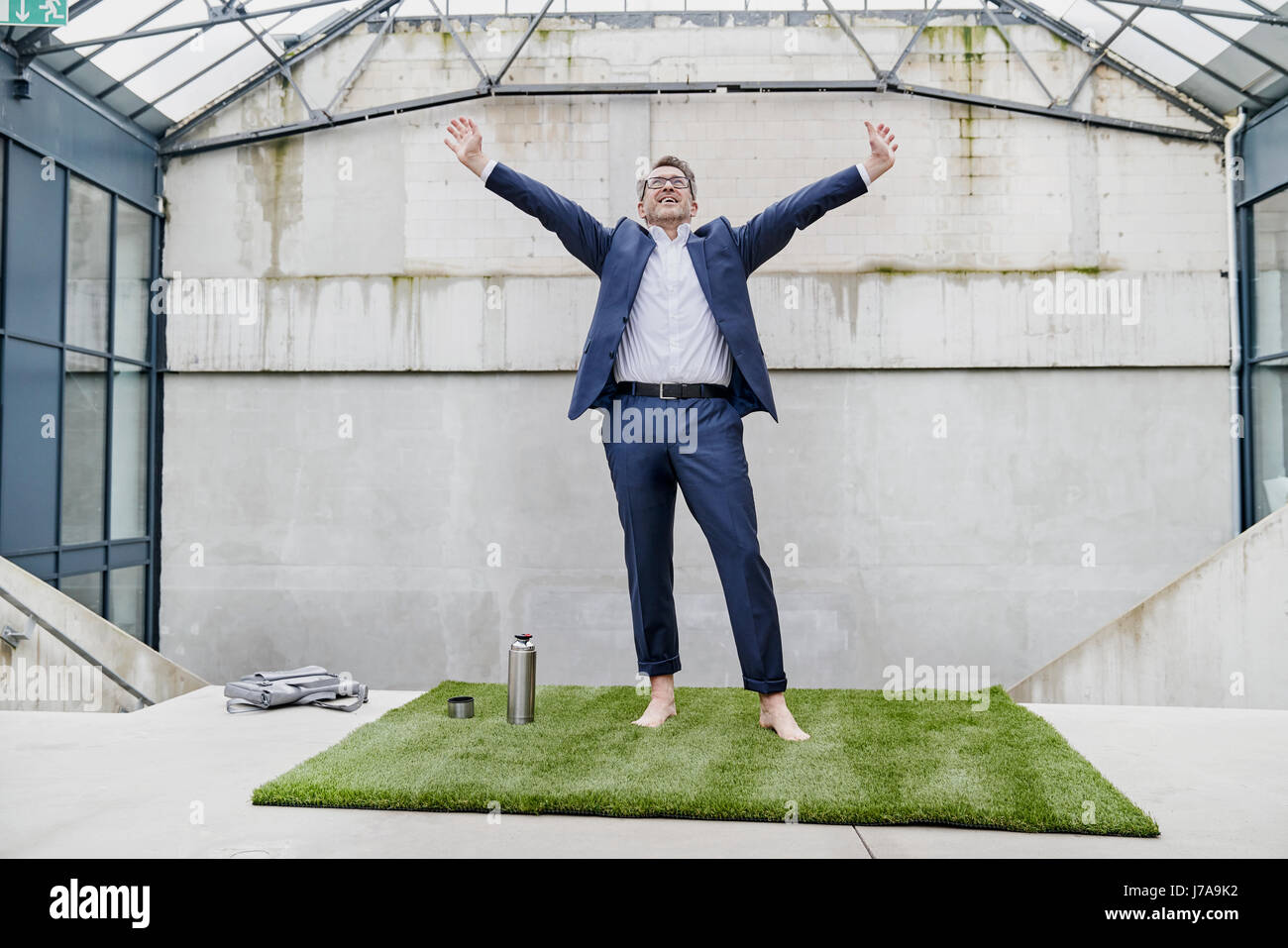 Funky imprenditore con bracci sollevati Foto Stock