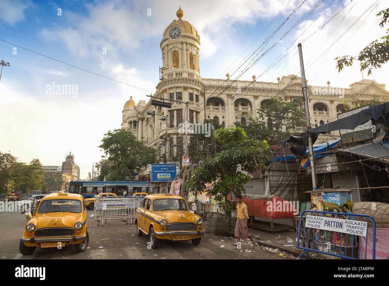 Il traffico della città con autobus e taxi di fronte vintage edificio metropolitano al esplanade il più trafficato della città intersezioni stradali di Kolkata. L'india. Foto Stock