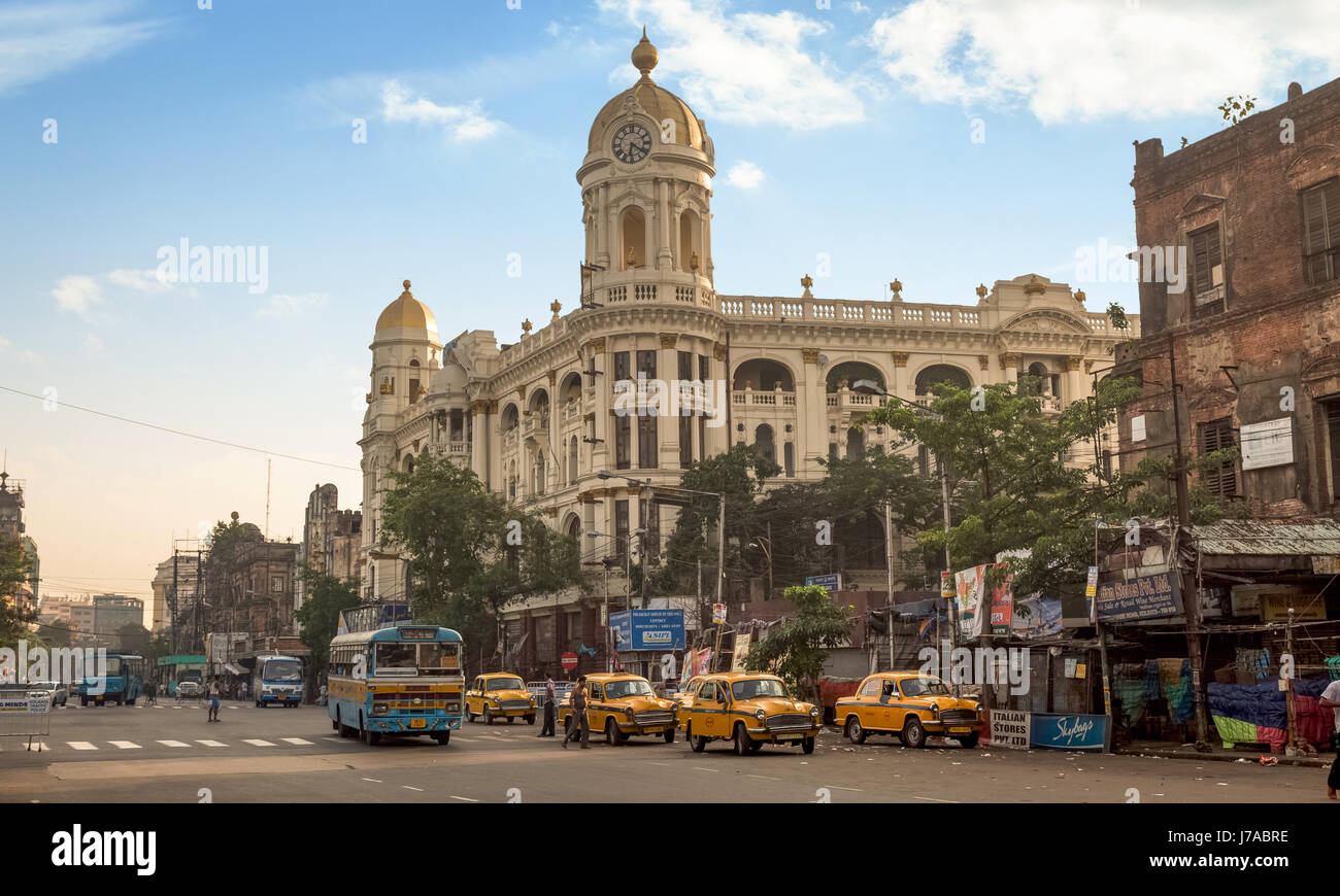 Il traffico della città con autobus e taxi di fronte vintage edificio metropolitano al esplanade il più trafficato della città intersezioni stradali di Kolkata. L'india. Foto Stock