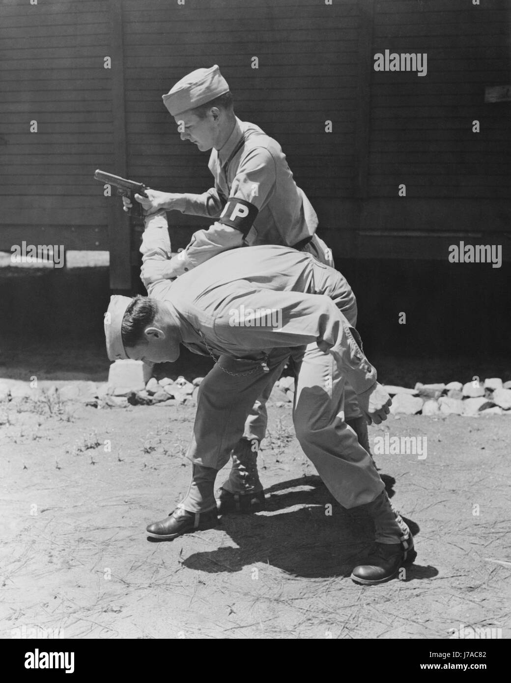 La polizia militare Privates pratica disarmare un pistolero, circa 1942. Foto Stock