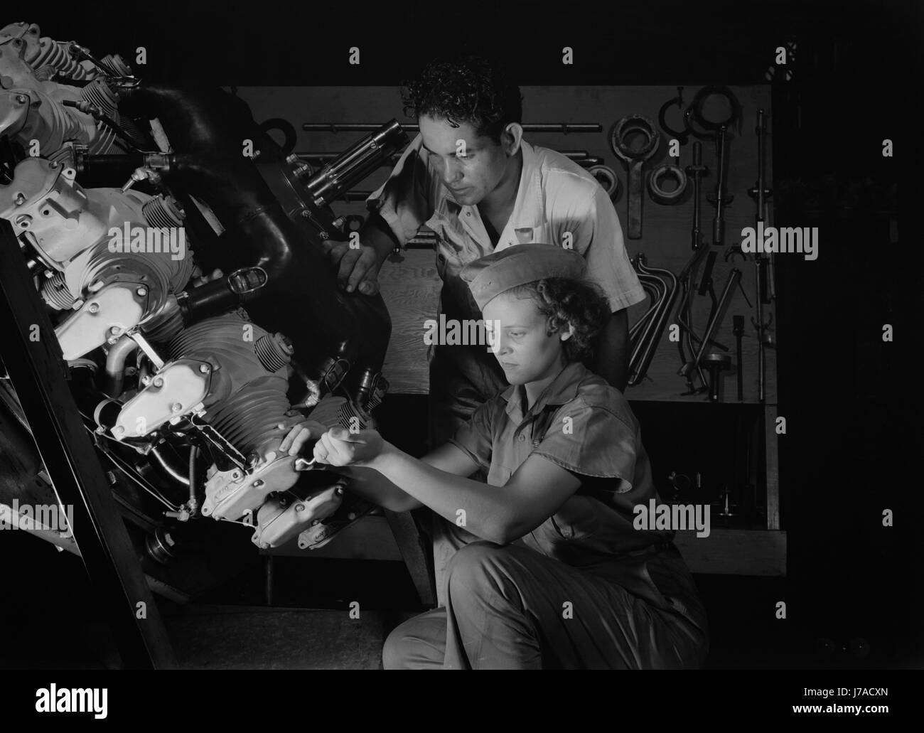 Un esperto meccanico mostra uno studente i trucchi di un motore aereo, 1942. Foto Stock