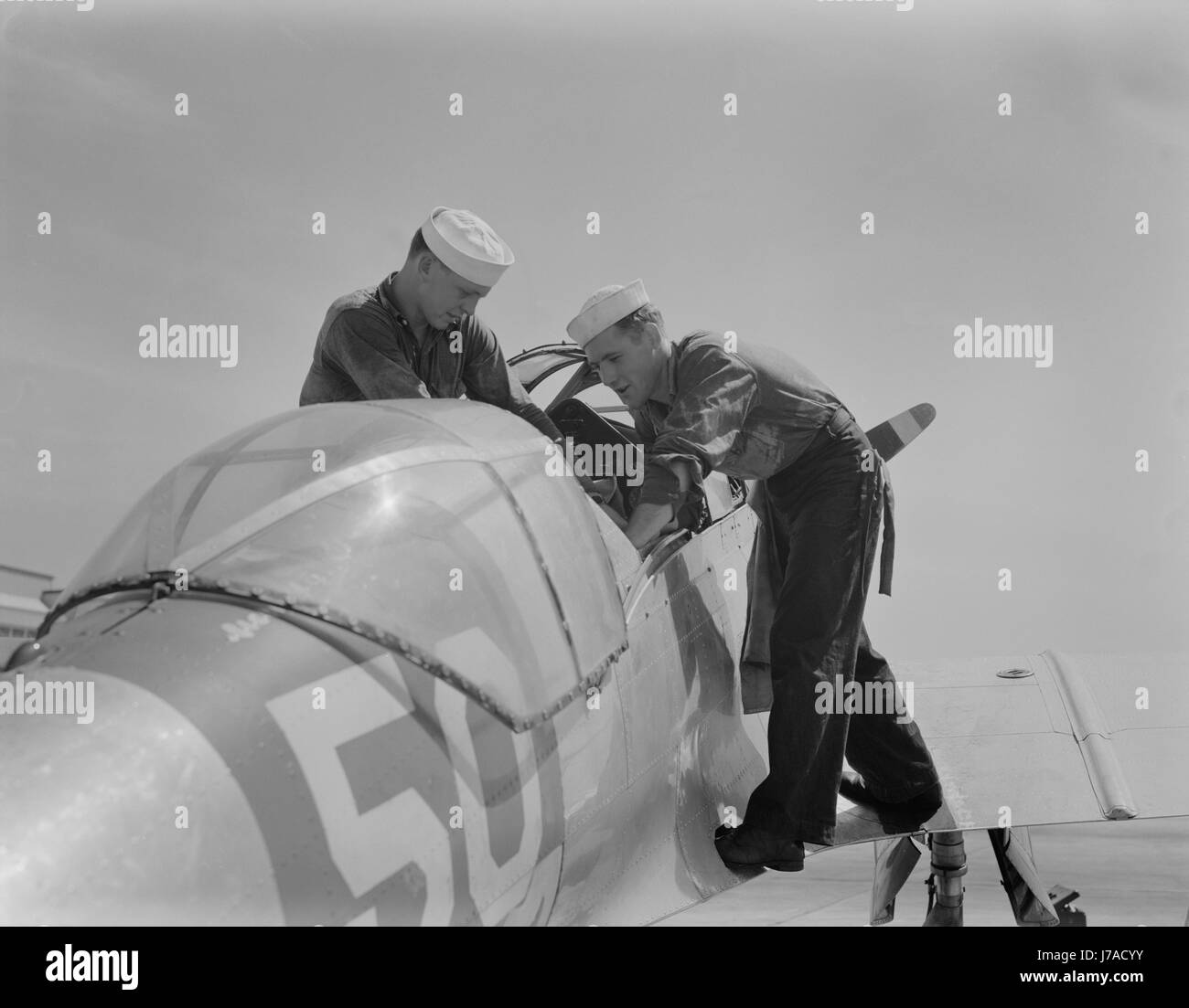 I marinai controllare la sede pilota di una SNC anticipo Piano di formazione, 1942. Foto Stock