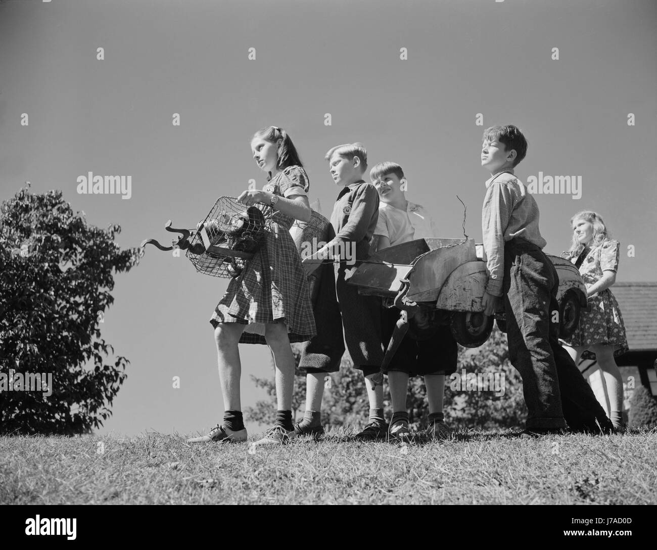 Bambini raccogliere i rottami di donare per le nostre industrie belliche, 1942. Foto Stock