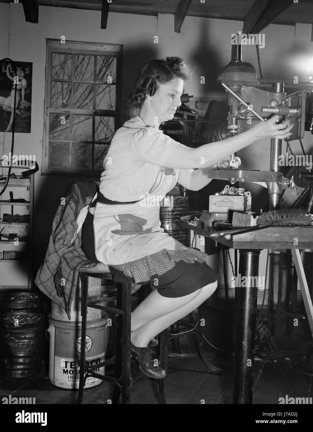 Una donna macchinista luoghi viti nei terminali elettrici nella sua officina, 1942. Foto Stock