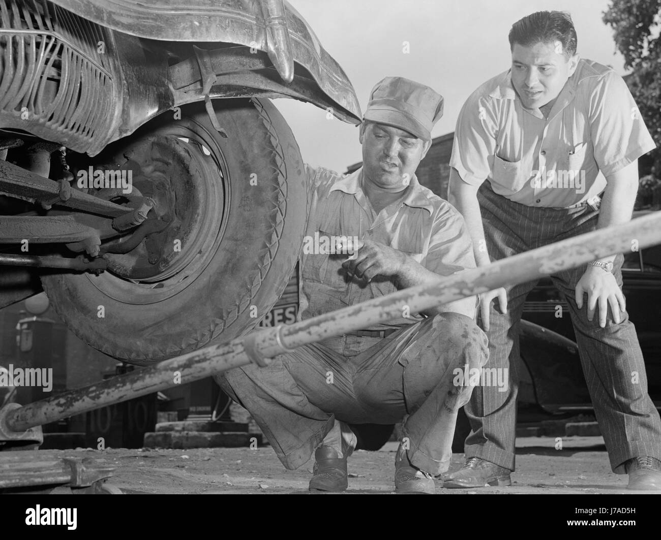 Un uomo ha pneumatici controllati e regolati per prevenire un'usura eccessiva dei pneumatici, 1942. Foto Stock