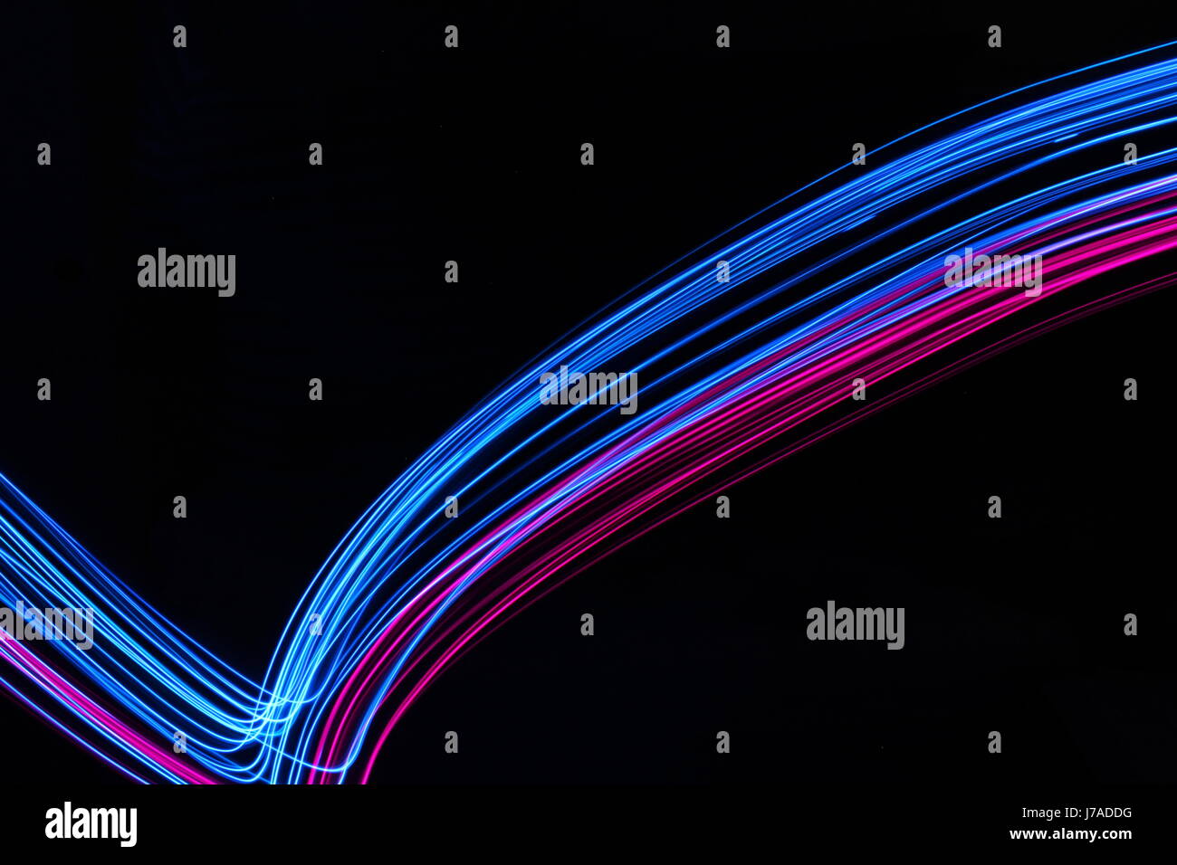 Una lunga esposizione fotografia di neon pink e il colore blu in una configurazione astratta contro uno sfondo nero. Luce fotografia pittura, di colore in astratto Foto Stock