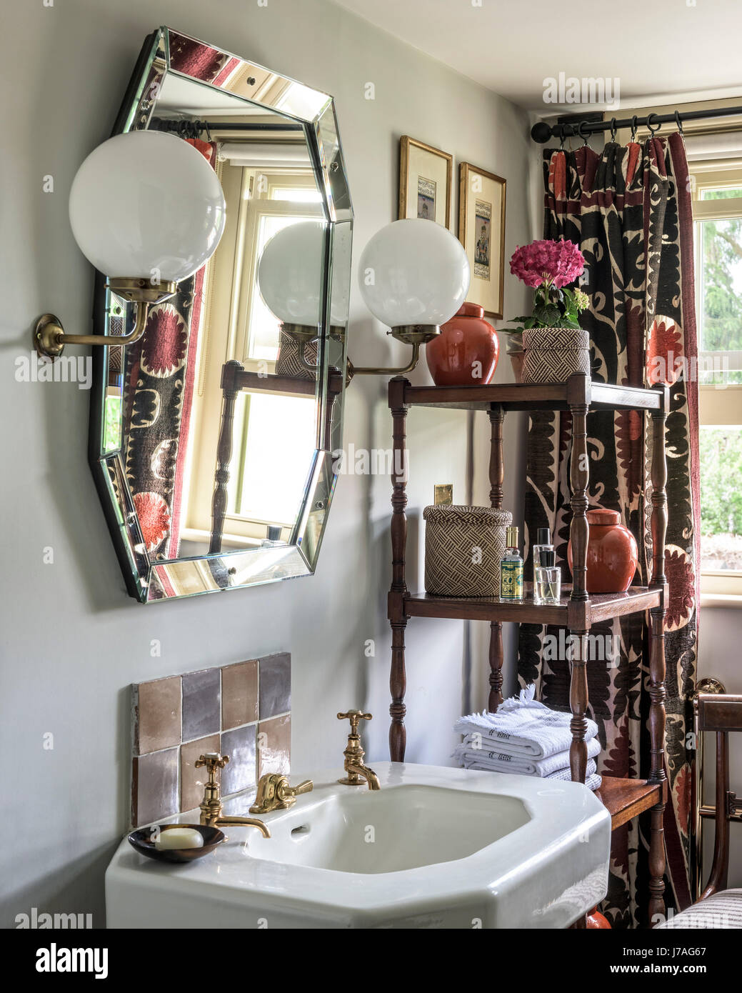 Due grandi luci di Orb e scaffali in legno con specchio vintage sopra lavandino Foto Stock