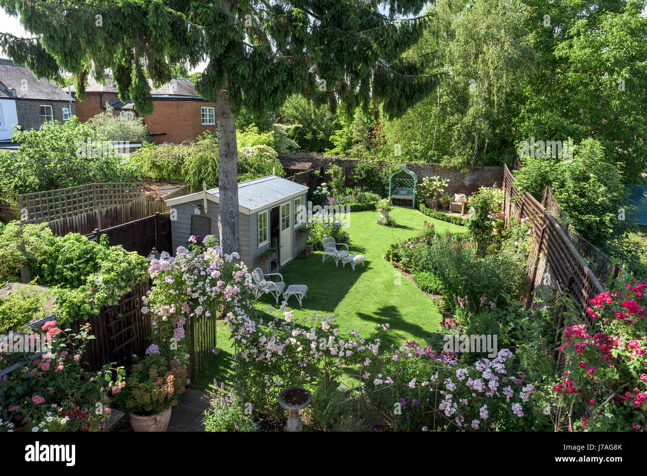 La vista dal balcone verso il basso per inglese il giardino murato con Summer house e arco di rose Foto Stock