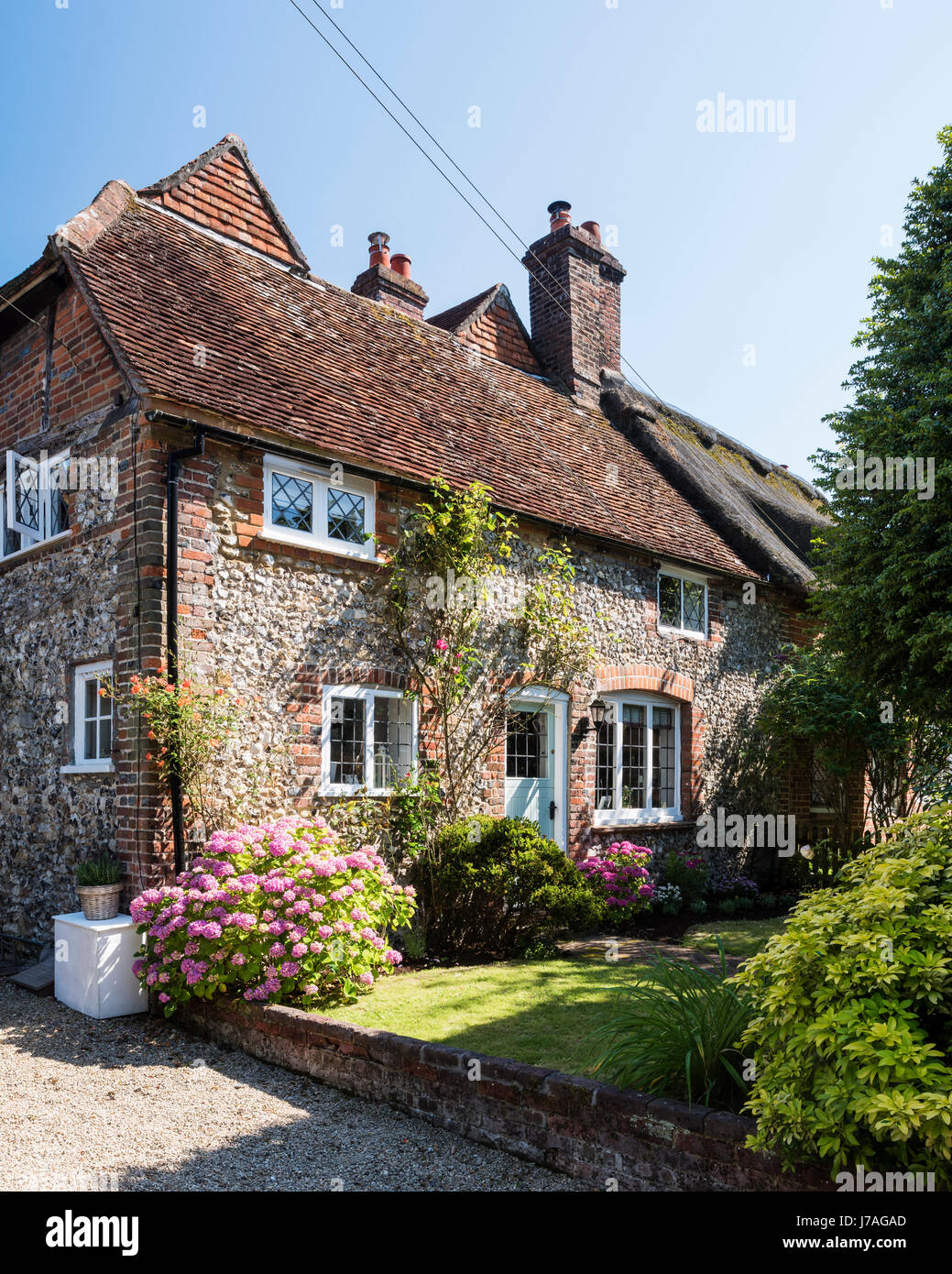 La facciata esterna di idilliaci Grade II in mattoni e pietra focaia cottage Foto Stock
