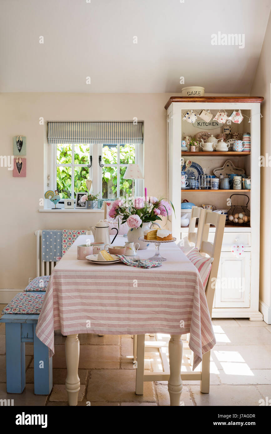 Tabella a strisce panno nel grazioso paese cucina con ticchettio tende a strisce da Ian Mankin Foto Stock