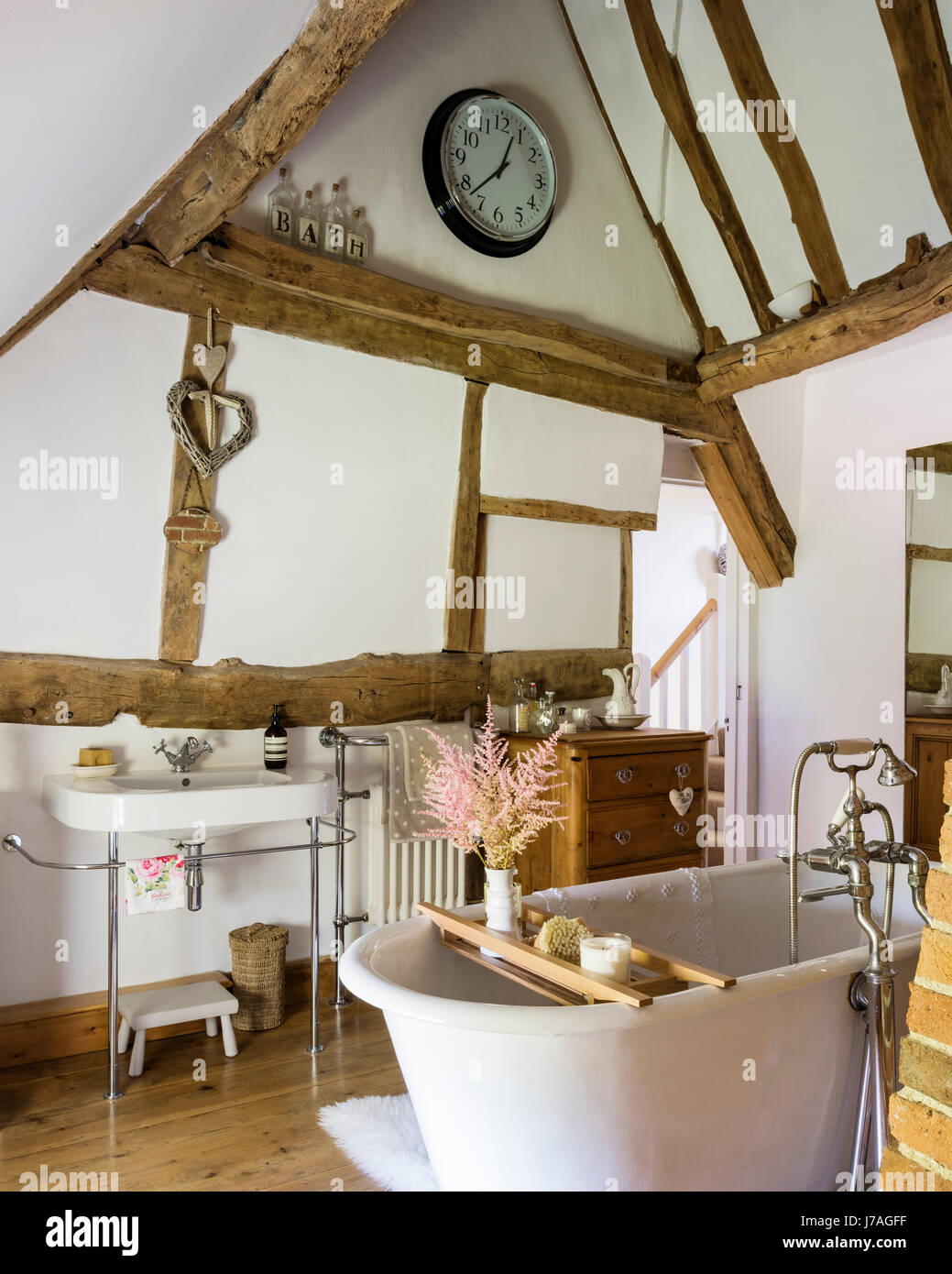 Bagno con soffitto a volta con le antiche travi e roll-top bagno francese. Il bacino è di Duravit Foto Stock