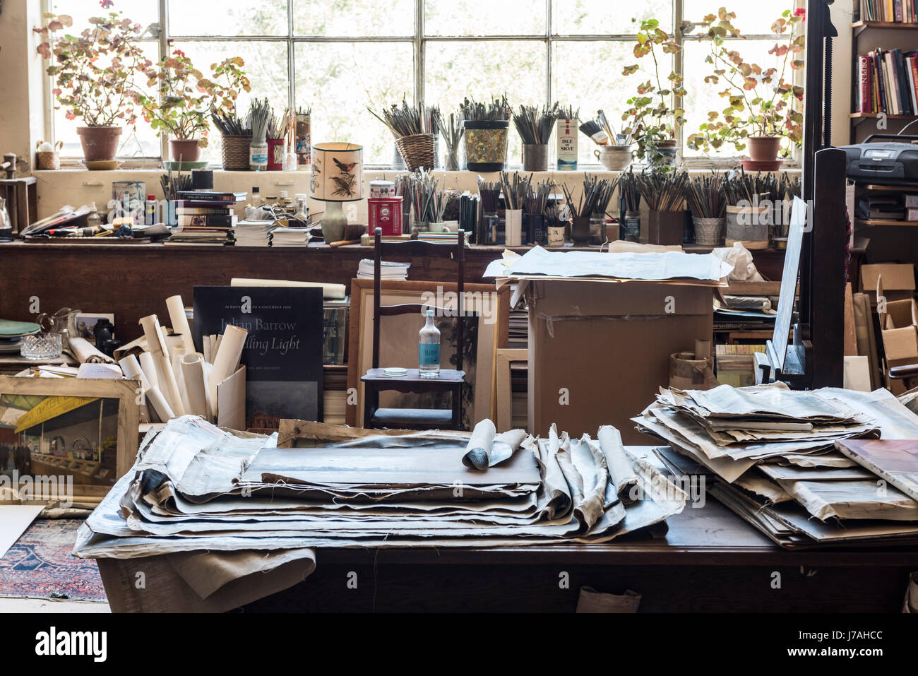 Senza cornice tele e pennelli in vasi in artisti bohemien studio con ampia finestra Foto Stock