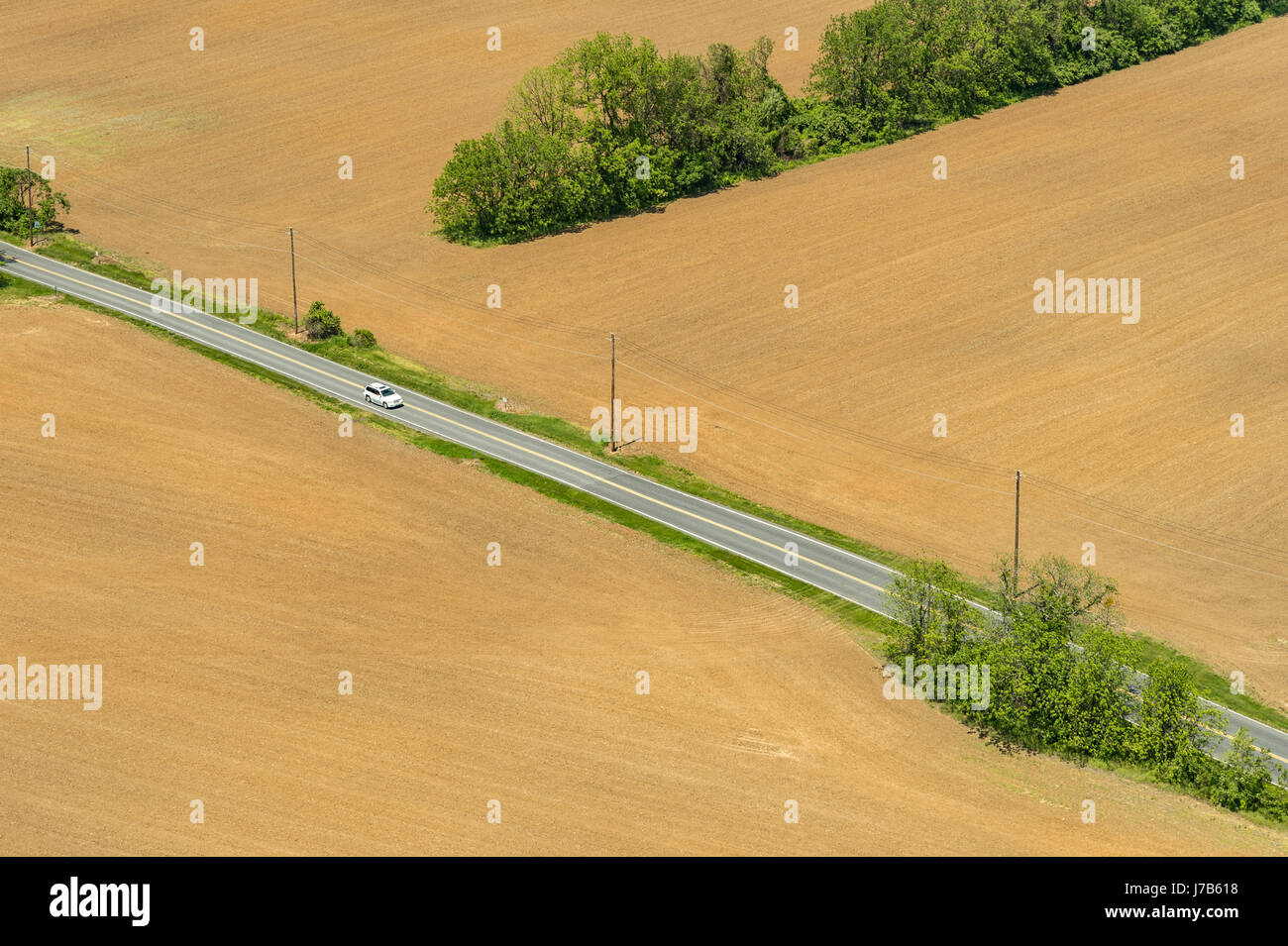 Vista aerea della sola auto sulla strada di campagna di guida attraverso i terreni agricoli, Pennsylvania, STATI UNITI D'AMERICA Foto Stock