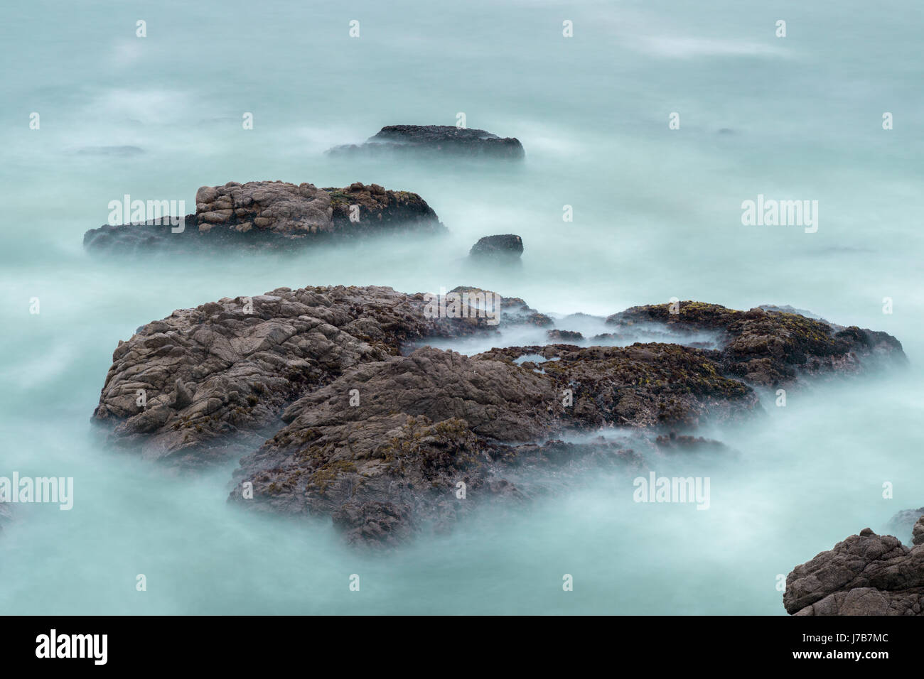 Una lunga esposizione delle onde e rocce nell'Oceano Pacifico. Foto Stock