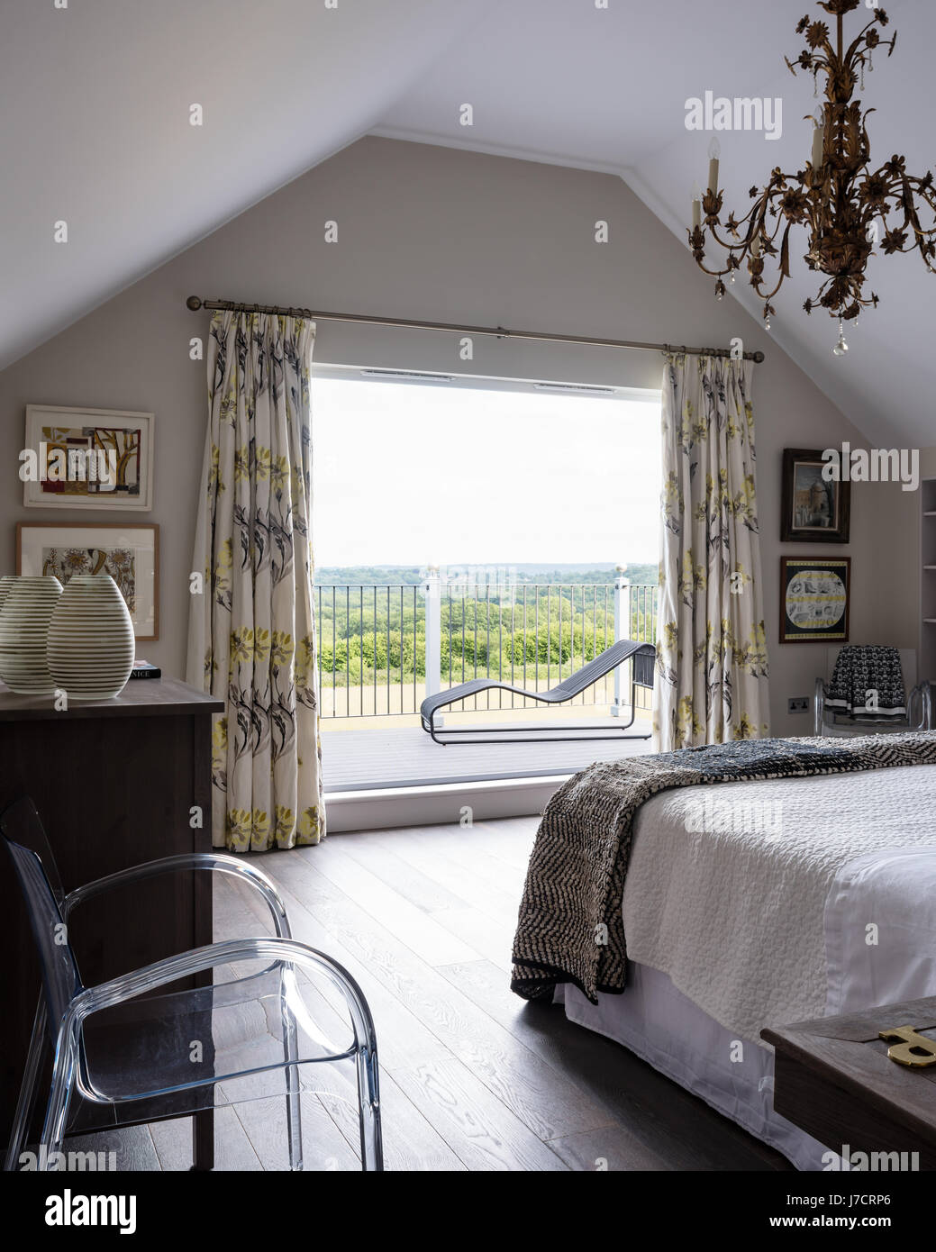 Finestra Immagine e balcone in camera da letto matrimoniale con poltrona in acrilico e arte grafica Foto Stock