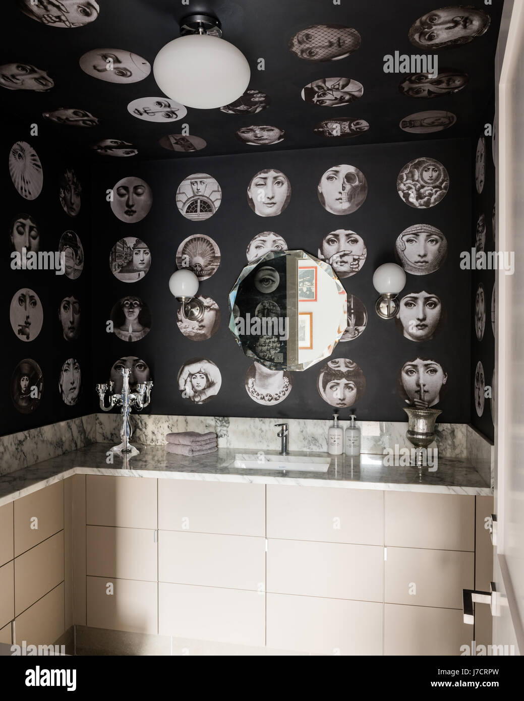 Carta da parati Fornasetti nella stanza da bagno in marmo con specchio  vintage Foto stock - Alamy