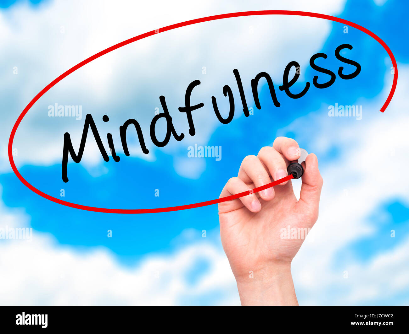 Man mano che scrive Mindfulness con pennarello nero su schermo visivo. Isolato su sky. Business, tecnologia internet concetto. Immagine di stock Foto Stock