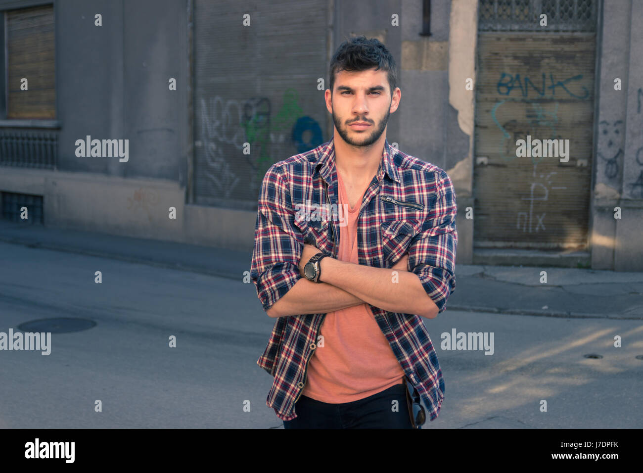 Giovane uomo ritratto, graffiti villaggio, città vecchia, all'aperto, abiti casual, all'aperto, street Foto Stock