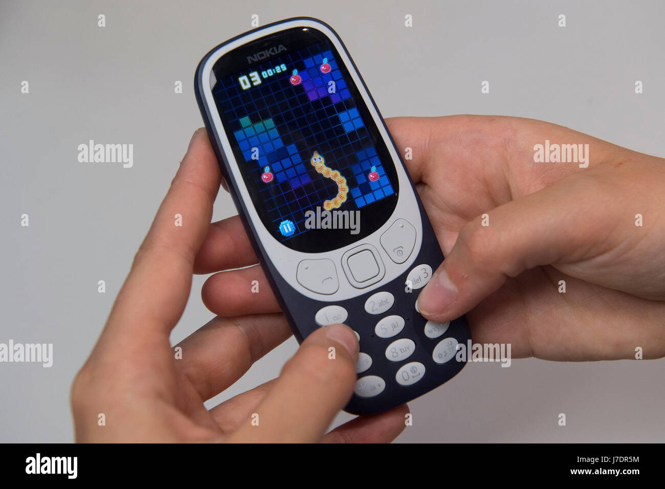 Una persona che interpreta il classico gioco per cellulare Snake come il nuovo Nokia 3310 telefono cellulare va in vendita presso la Carphone Warehouse su Oxford Street, Londra. Foto Stock
