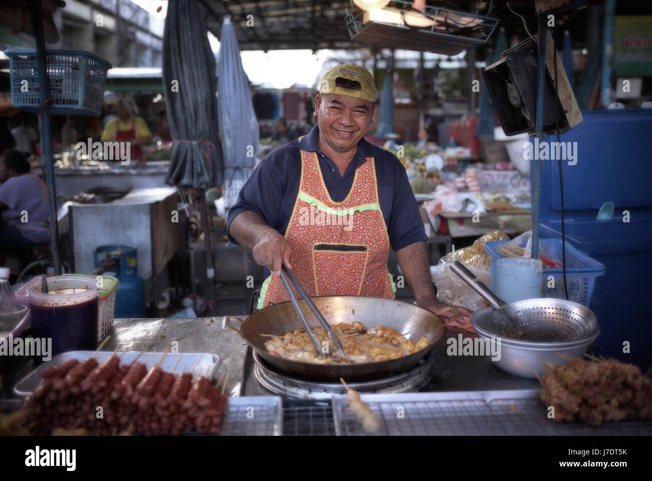 Thailandia street market alimentare fornitore. Uomo tailandese per la cottura all'aperto. Sud-est asiatico Foto Stock