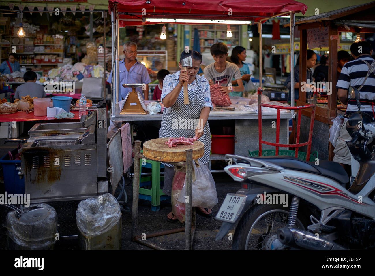 Thailandia street market alimentare fornitore. Donna Thai preparare la carne all'aperto. Sud-est asiatico Foto Stock