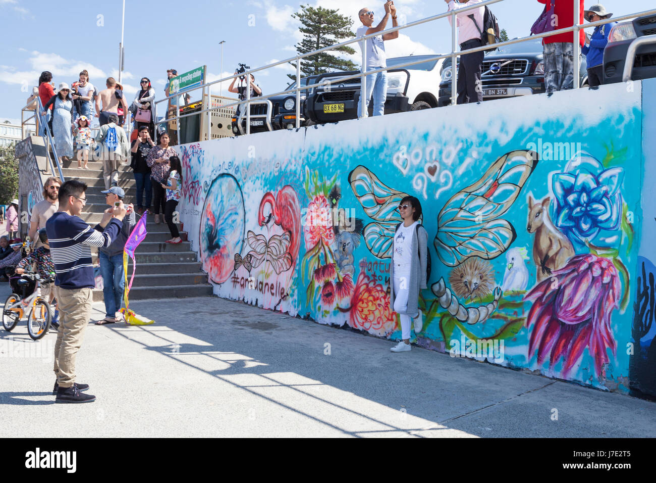 Turistica prendendo foto murale contro pareti, pareti di graffiti, della passeggiata sulla spiaggia Bondi, Sydney Foto Stock