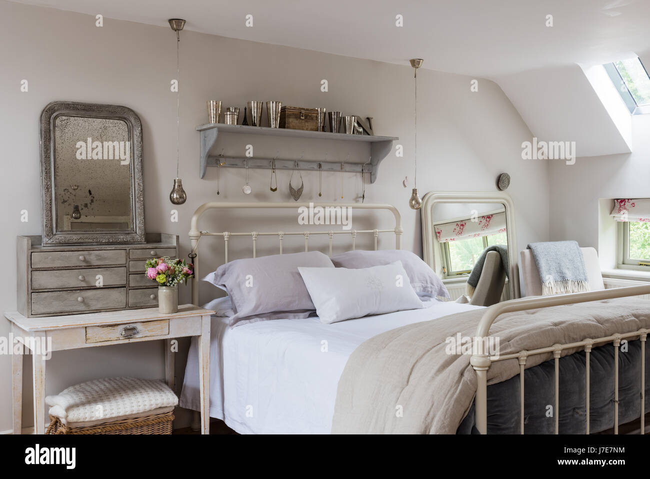 Letto di ferro battuto da piuma & nero nella sensazione rustica camera da letto con le pareti dipinte di scrematura di pietra da Farrow & Ball Foto Stock