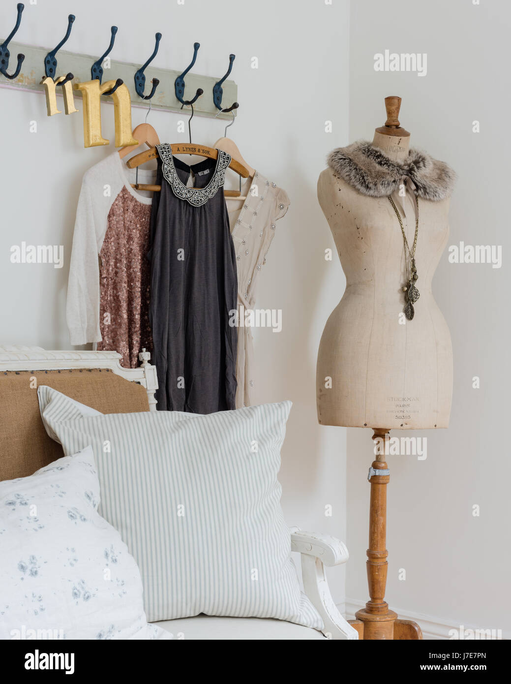 Elegante manichino in camera da letto in stile rustico con appendiabiti e cuscini dal Cavoli & Rose Foto Stock