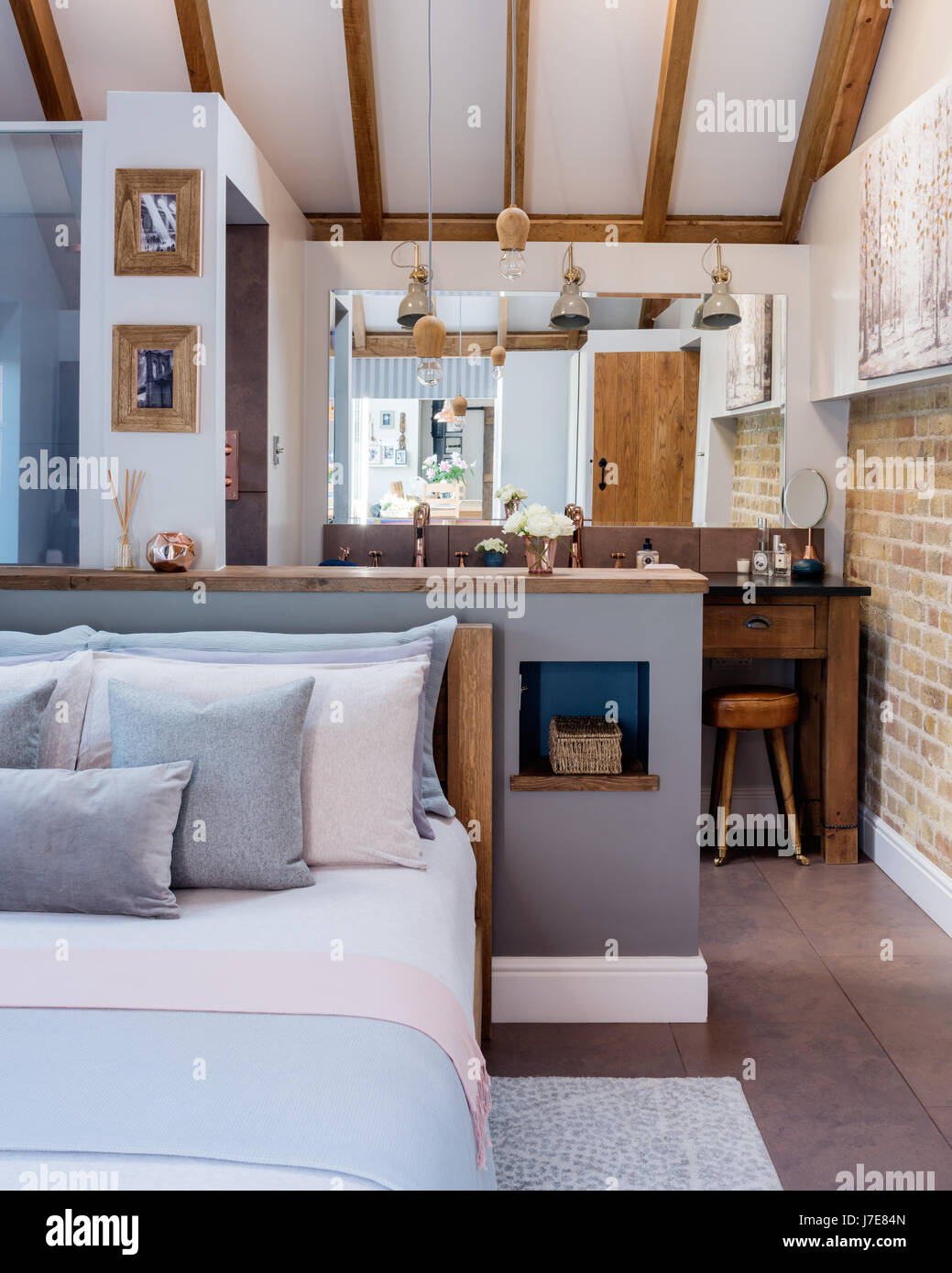 Boutique chic camera da letto con un luminoso germoglio luci in legno da Nordic Tales. L'armadio dietro il letto è dipinto in una mole di respiro da parte Farrow & Ball e Foto Stock